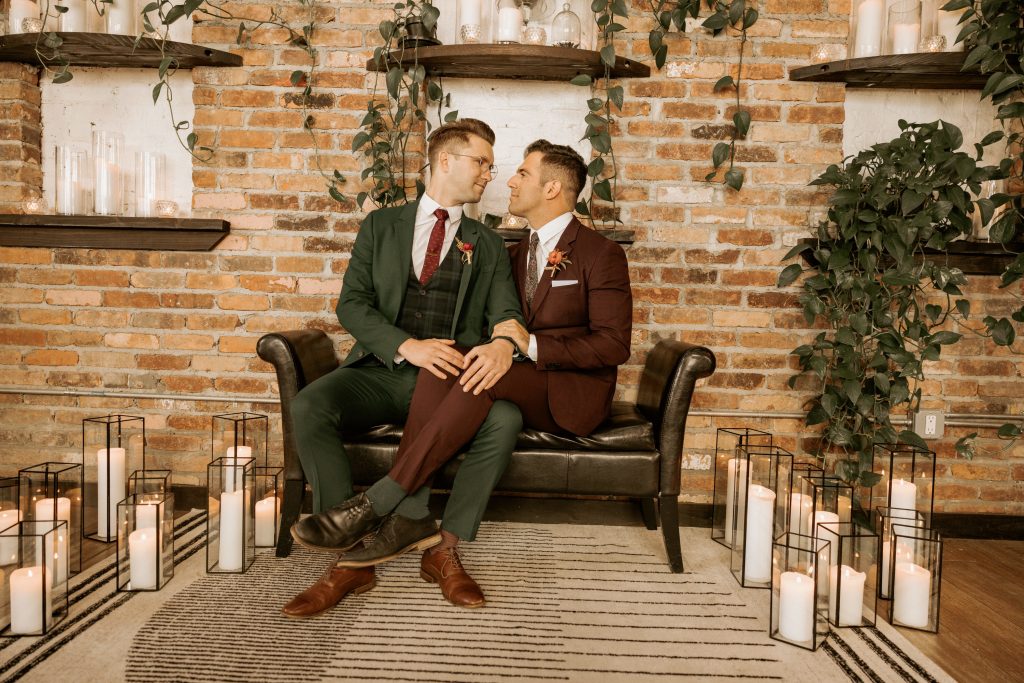 gay couple grooms cuddle on bench