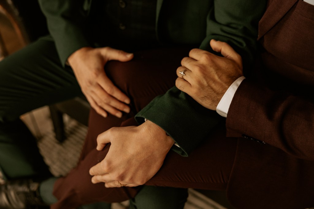 hands tangled together grooms in suits